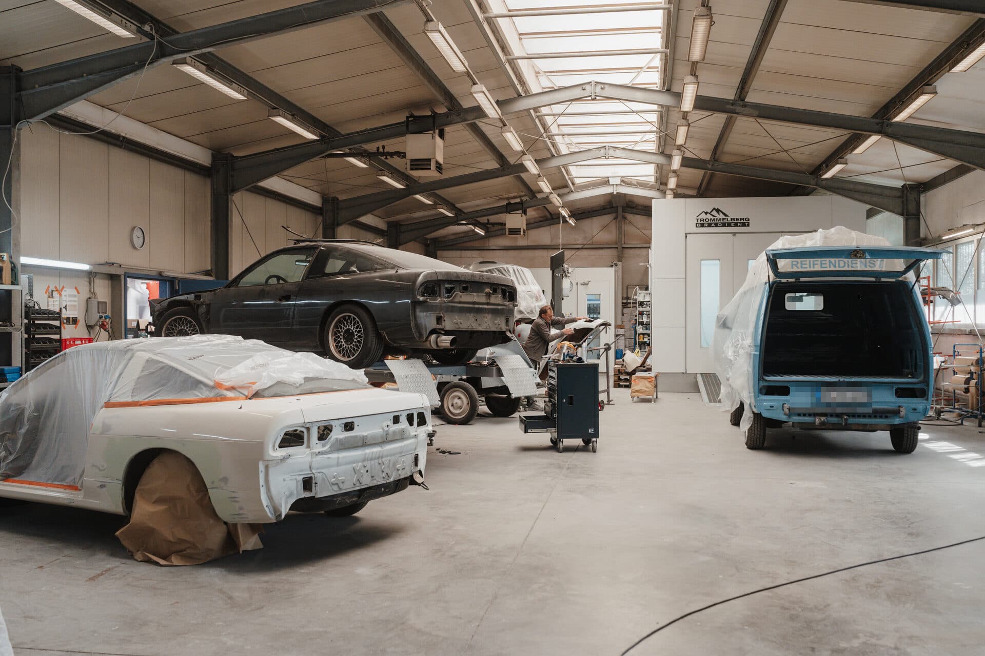 Werkstatthalle mit mehreren Fahrzeugen in Arbeit